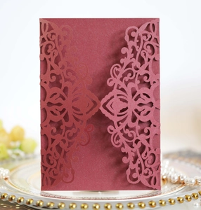 Detailed laser-cut vine patterns on burgundy cardstock invitation for wedding and events