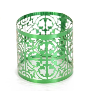 Detailed macro view of laser-cut green metallic napkin ring with vintage floral patterns