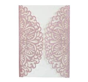 Detail of rose gold glitter laser-cut wedding invitation cover with intricate floral lace