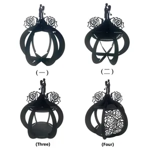 Detail of four black laser-cut paper lanterns featuring romantic couple and rose patterns