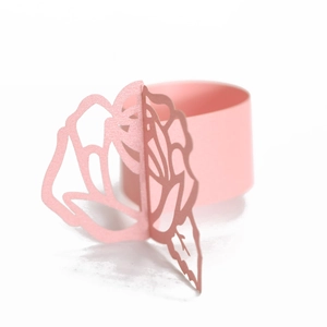 Detail of pink pearlescent paper napkin ring with a laser-cut 3D rose flower design