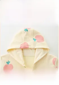 Detailed close-up of girls cotton hoodie with peach prints and zipper closure