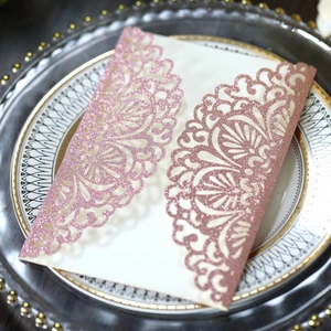 Detailed laser-cut lace pattern on rose gold glitter wedding invitation card