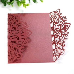 Detailed laser-cut wine red invitation cover with intricate floral patterns and shimmer texture