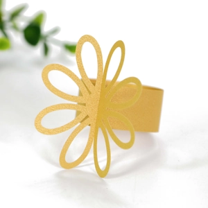 Close-up of bright yellow daisy paper napkin ring with hollow petal design and glossy finish