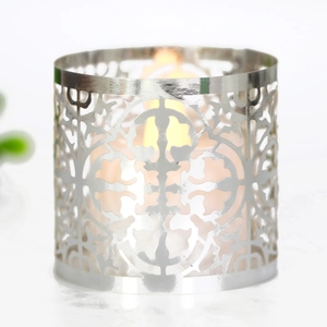 Macro detail of silver metal candle holder with laser-cut hollow geometric patterns