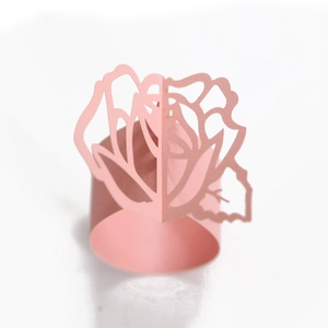 Detailed laser-cut pink paper napkin ring featuring a 3D rose flower design for weddings
