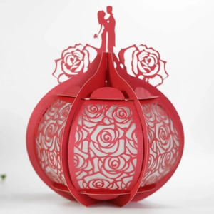 Detailed laser-cut red 3D paper lantern with hollow rose patterns and couple silhouette