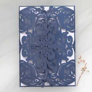 Detailed laser-cut navy blue wedding invitation card featuring intricate floral lace patterns