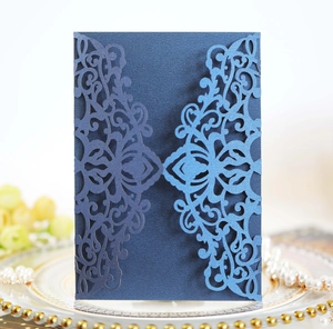 Close-up of laser-cut lace pattern on navy blue pearlescent paper wedding invitation