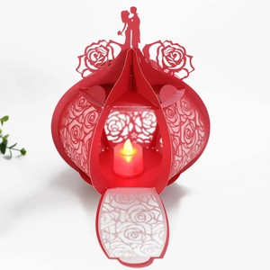 Detailed laser-cut hollow rose patterns on a red paper lantern with warm LED candle light