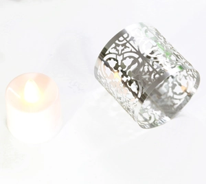 Macro detail of laser-cut hollow pattern on silver metal candle holder sleeve