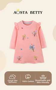Détail de la robe rose en coton pour fille avec broderie florale et épaules à volants