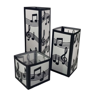Three-piece black music staff candle covers with musical note cutouts and frosted panels