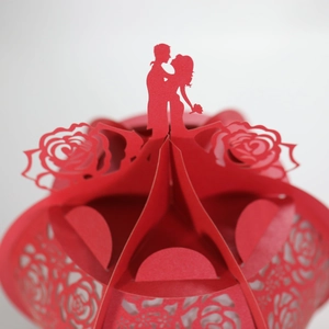 Close-up of laser-cut red paper lantern with romantic couple silhouette and rose motifs