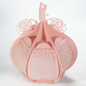 Detail of pink laser-cut paper gift box featuring rose patterns and a romantic couple silhouette