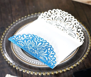 Detailed view of white laser-cut invitation envelope with blue glitter border details