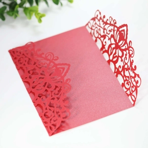 Detail of red laser-cut wedding invitation card with intricate floral pattern