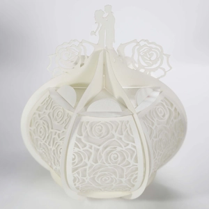 Detailed laser-cut white paper wedding lantern with romantic rose patterns and couple silhouette