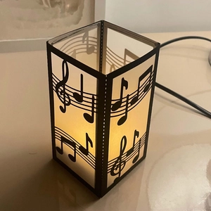 Macro shot of musical staff and notes on a translucent laser-cut black paper lampshade