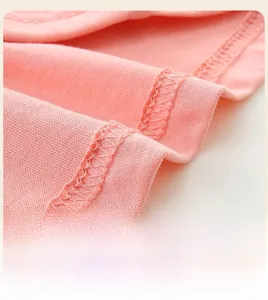 Détail de l'ourlet de la robe en coton rose montrant une couture soignée et coupe en A