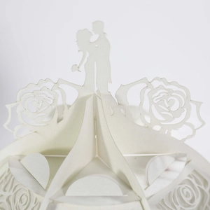 Macro shot of laser-cut 3D white paper lantern featuring a romantic wedding couple silhouette