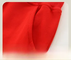 Détail du pantalon rouge pour enfants montrant la poche latérale et la broderie nuage