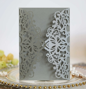 Intricate laser-cut patterns on grey pearlescent paper invitation with floral details