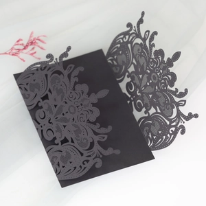 Detailed macro shot of black laser-cut floral wedding invitation with intricate patterns