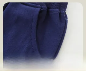Detailed close-up of navy knit pants showing the ribbed waistband and pocket stitching