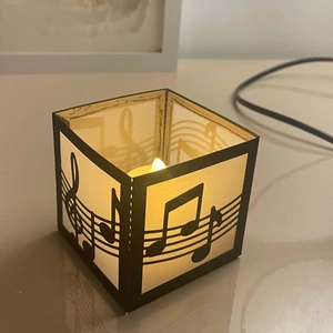Close-up of music note hollow paper lampshade with warm glowing LED candle light