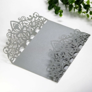 Detail of silver laser-cut lace pattern on pearlescent paper wedding invitation cover
