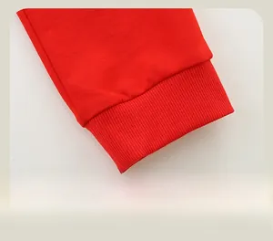 Détail de jogging rouge montrant les poignets côtelés élastiques et la texture du tissu
