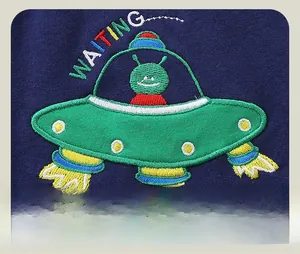 Detailed view of colorful UFO and alien rocket embroidery on navy cotton kids pants