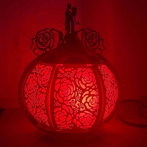 Detail view of red hollow rose laser-cut lamp with romantic couple silhouette