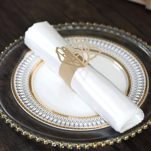 Elegant laser-cut golden butterfly napkin ring on white cloth for wedding table decor