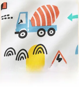 Détail du tissu d'un sweat à capuche blanc pour garçon avec camions et montagnes