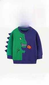 Detailed close-up of dragon embroidery and 3D purple fins on green cotton sweatshirt