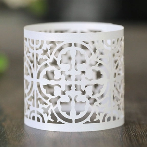 Detailed laser-cut white paper cupcake wrappers with intricate floral patterns for weddings