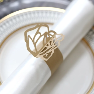 Macro shot of laser-cut gold paper napkin ring with elegant rose flower design detail
