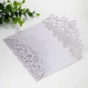 Detail of laser cut lace patterns on a light purple pearlescent wedding invitation cover