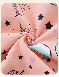 Close-up of soft pink cotton fabric with unicorn, star and heart patterns for girls