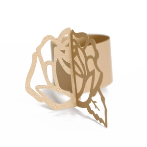 Close-up of laser-cut gold pearlescent paper napkin ring with 3D hollow rose flower