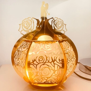 Detail of golden rose hollow out lantern with warm light and couple silhouette