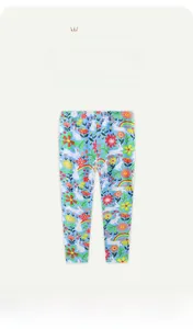 Détail de legging bleu élastique avec imprimé lapin, fleurs et arc-en-ciel pour fille