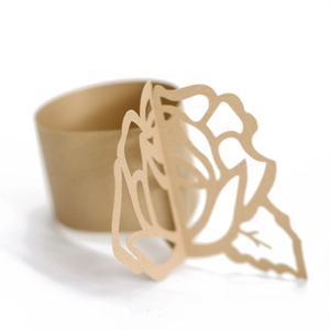 Macro detail of laser-cut rose pattern on kraft paper napkin ring for weddings