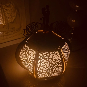 Detail of hollow rose paper lantern with romantic couple silhouette and warm LED glow