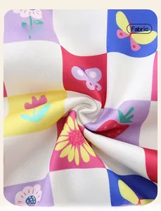Close-up of soft cotton fabric with colorful checkered pattern and floral butterfly prints