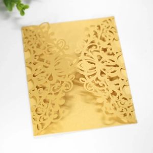 Detail of laser-cut floral lace pattern on golden pearlescent paper invitation sleeve
