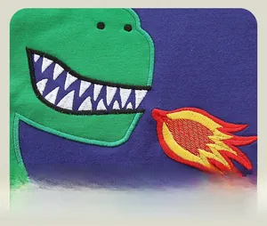 Detail of green dinosaur applique with 3D flocking on purple cotton sweatshirt